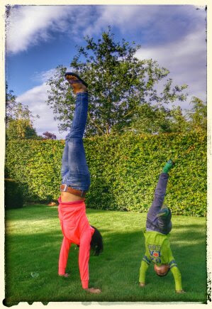 Outdoor yoga practice near the ocean. Young woman practicing Adho Mukha  Vrksasana. Yoga Handstand is an inverted asana. Beautiful asana. Strong  slim body. Yoga retreat. Copy space. Bali Stock Photo